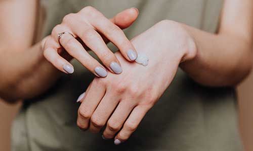 Woman applying wart removal cream